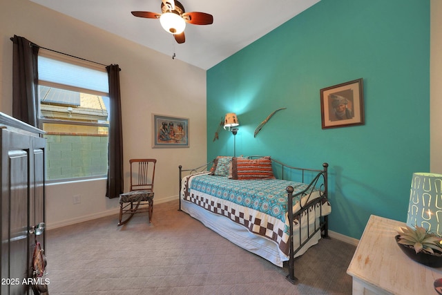 carpeted bedroom featuring baseboards and a ceiling fan