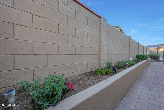 exterior space with concrete block siding and a fenced backyard