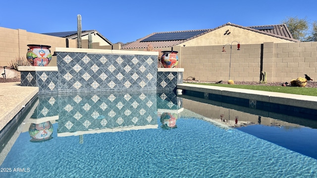 view of pool with a fenced backyard