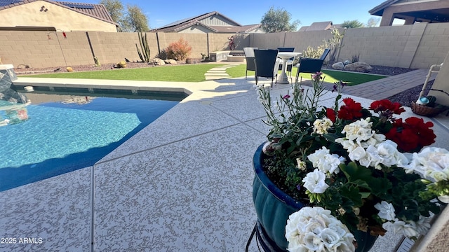 view of swimming pool featuring a patio, a yard, a fenced backyard, and a fenced in pool