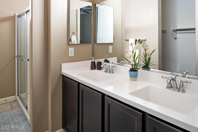 bathroom featuring a shower with door, tile patterned flooring, ceiling fan, and vanity