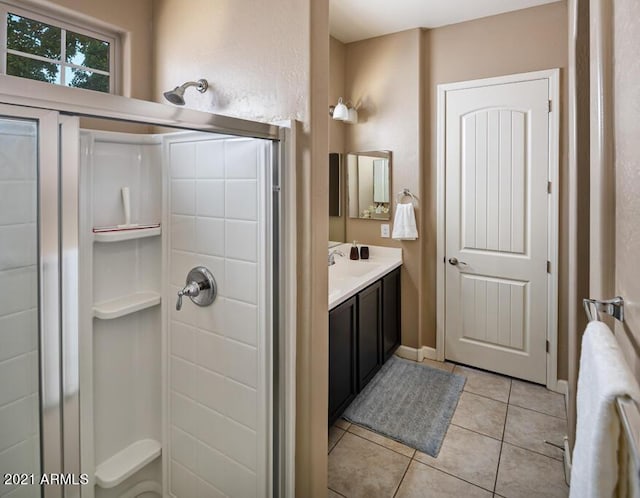 bathroom with a shower, tile patterned floors, and vanity