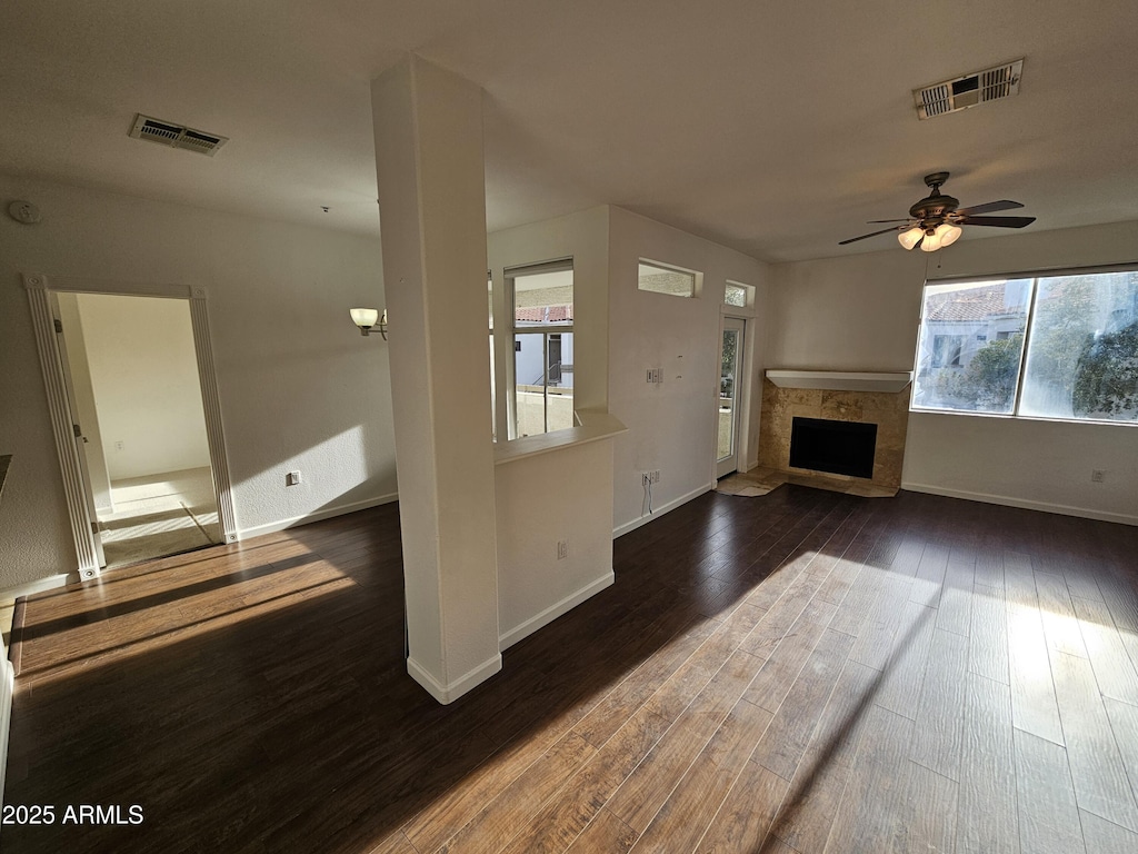 unfurnished living room featuring ceiling fan and dark hardwood / wood-style flooring