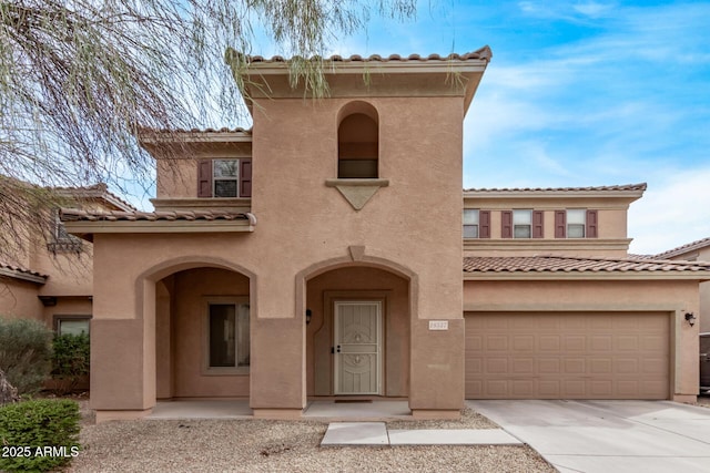 view of front of house with a garage, driveway, and stucco siding