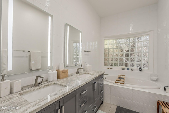 bathroom featuring a bath, double vanity, and tile patterned flooring