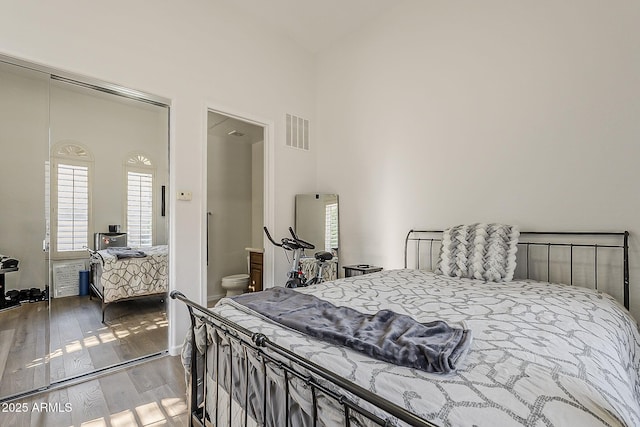 bedroom featuring wood-type flooring and high vaulted ceiling