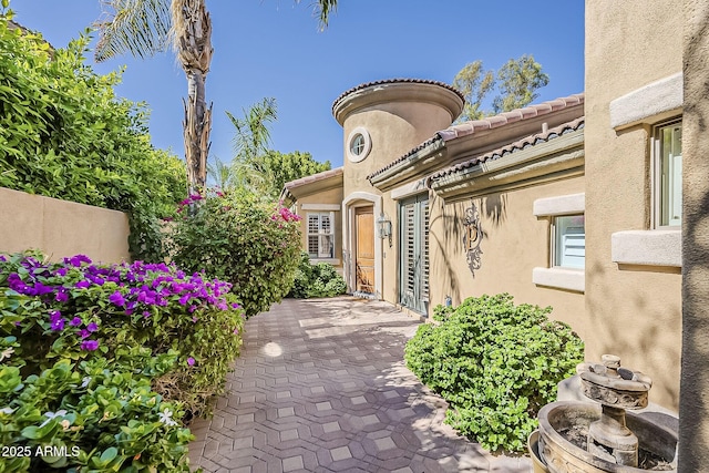 property entrance with stucco siding and a tile roof