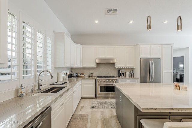 kitchen with stainless steel appliances, a sink, plenty of natural light, recessed lighting, and white cabinetry