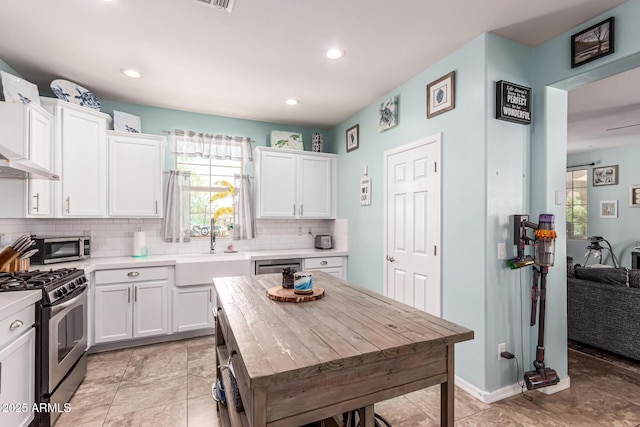 kitchen with stainless steel appliances, light countertops, a sink, and a healthy amount of sunlight