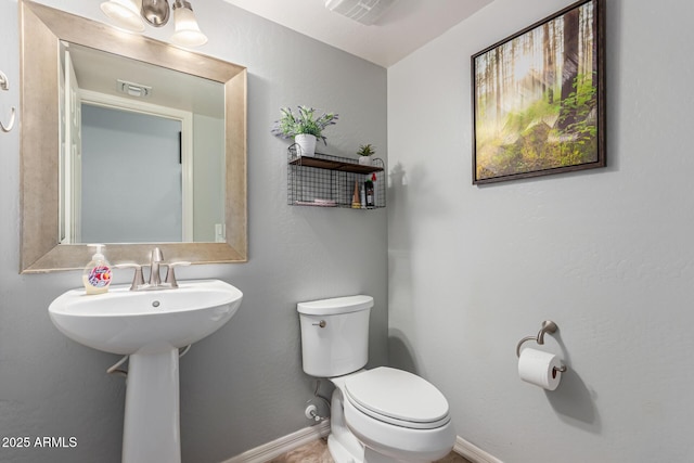 bathroom with visible vents, baseboards, and toilet