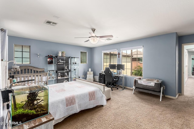 carpeted bedroom featuring baseboards, a ceiling fan, and visible vents