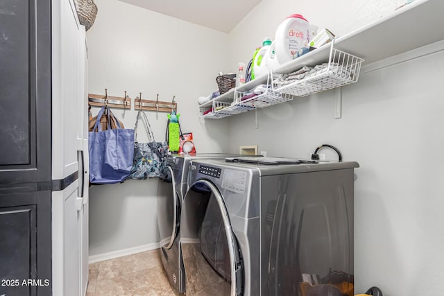 clothes washing area with baseboards, laundry area, and washing machine and clothes dryer