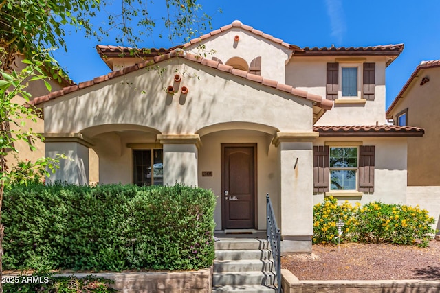 mediterranean / spanish-style house featuring stucco siding and a tile roof