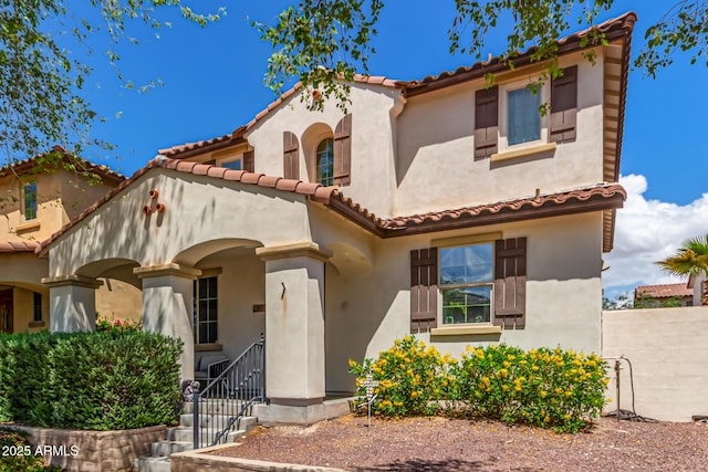 mediterranean / spanish-style home with stucco siding and a tile roof