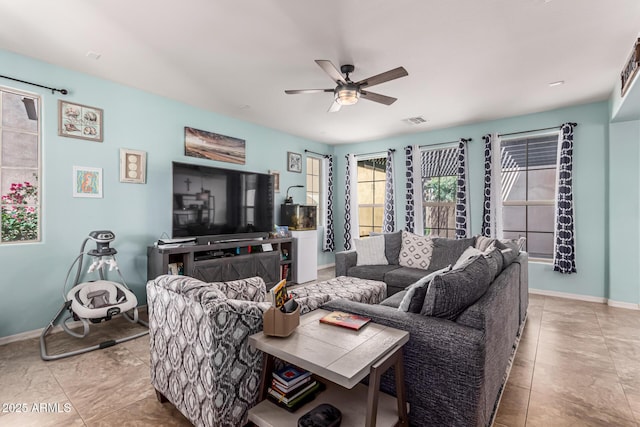 tiled living area with ceiling fan, baseboards, and visible vents