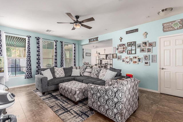 living room with visible vents, ceiling fan, and baseboards