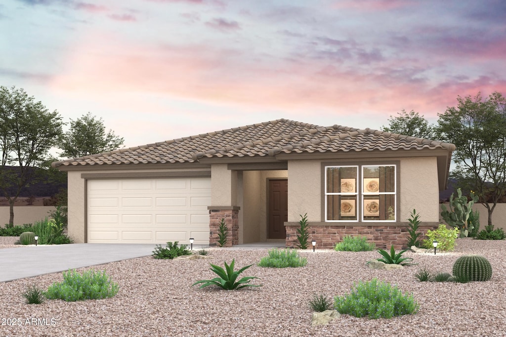 mediterranean / spanish home featuring a garage, concrete driveway, stone siding, a tiled roof, and stucco siding