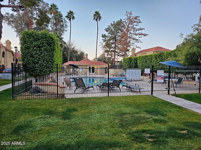 community pool featuring a yard and fence