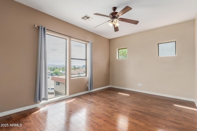 spare room featuring a ceiling fan, wood finished floors, and baseboards