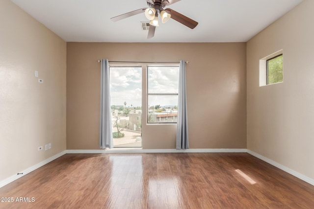 empty room featuring wood finished floors, ceiling fan, and baseboards