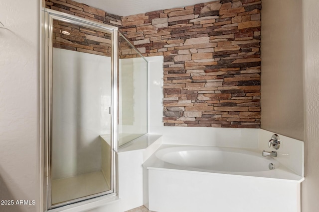 bathroom featuring a shower stall and a bath