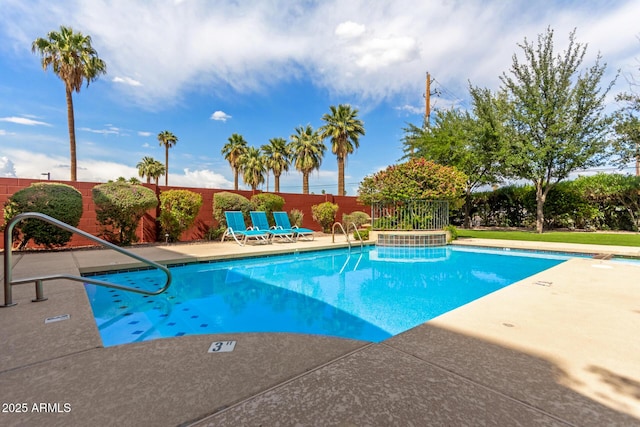 community pool with a patio and fence