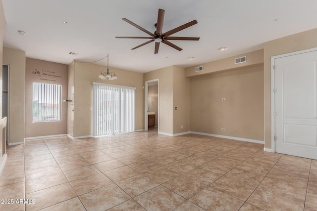 unfurnished room with ceiling fan, light tile patterned floors, a chandelier, and baseboards