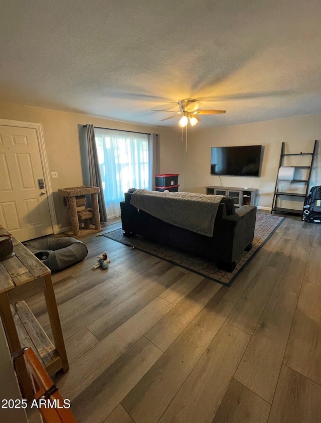 bedroom featuring ceiling fan, a textured ceiling, and wood-type flooring