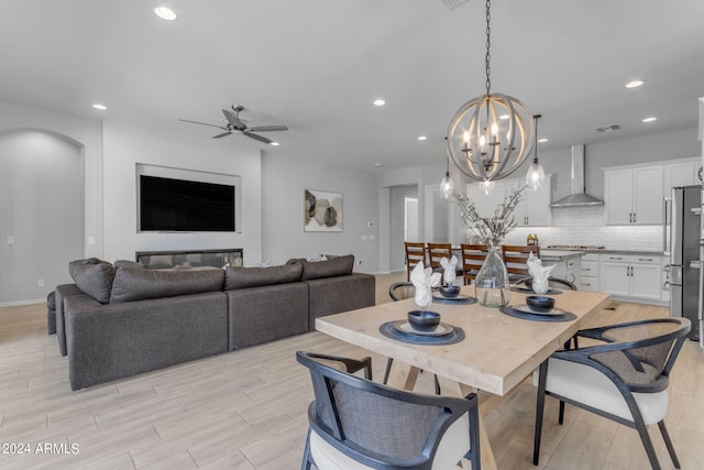 dining space featuring ceiling fan with notable chandelier and light hardwood / wood-style floors