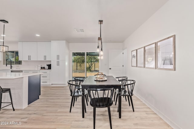 dining room with sink and light wood-type flooring