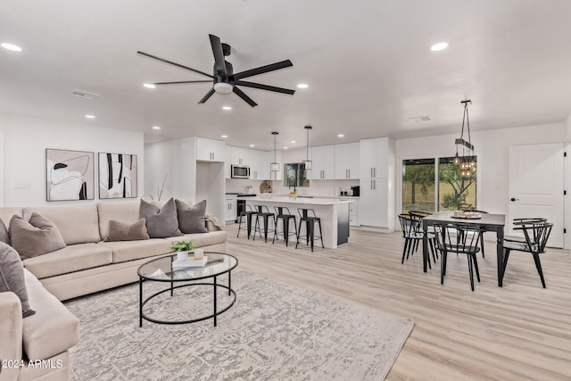 living room with light hardwood / wood-style flooring and ceiling fan