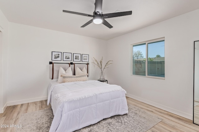 bedroom with light hardwood / wood-style floors and ceiling fan