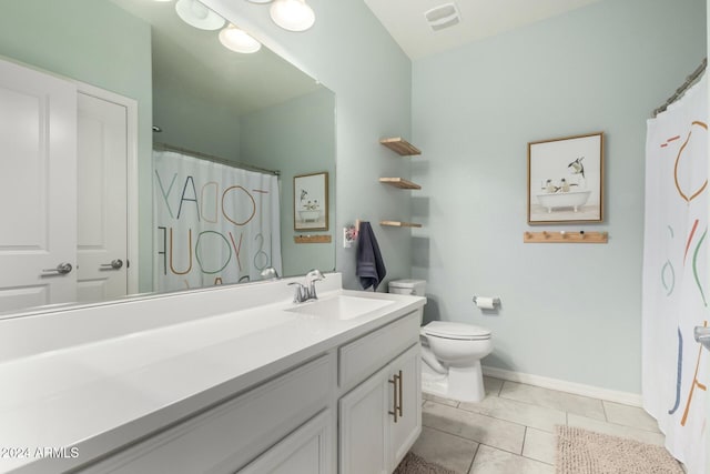 bathroom featuring tile patterned flooring, a shower with curtain, vanity, and toilet