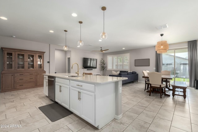 kitchen with a center island with sink, dishwasher, white cabinetry, and hanging light fixtures