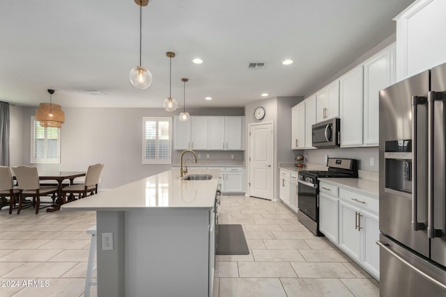 kitchen with sink, decorative light fixtures, a kitchen island with sink, white cabinets, and appliances with stainless steel finishes