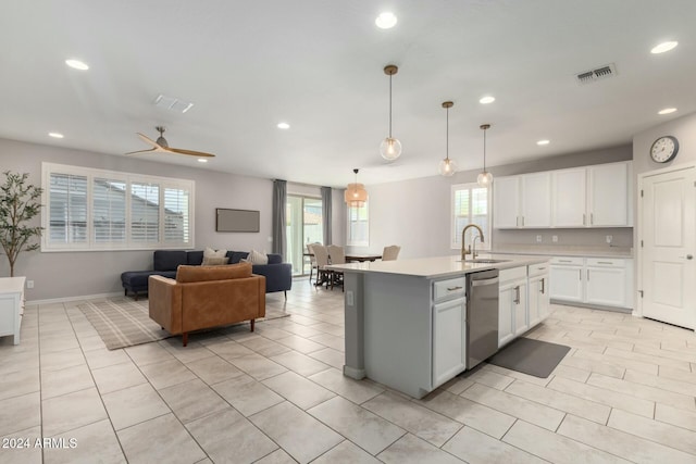 kitchen featuring stainless steel dishwasher, a kitchen island with sink, ceiling fan, pendant lighting, and white cabinets