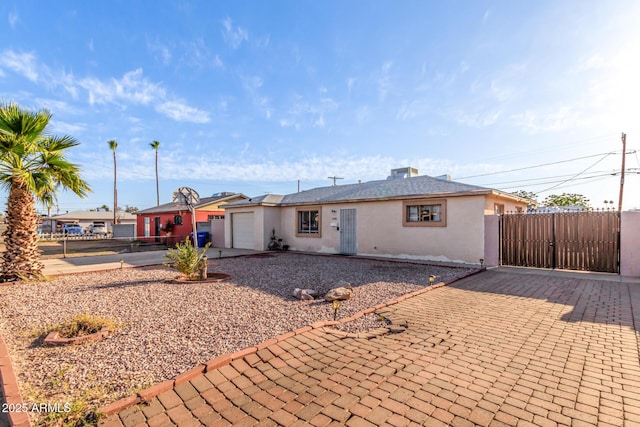 4408 N 29th Ave, Phoenix, AZ 85017 - back of house with stucco siding, a garage, driveway, and a gate