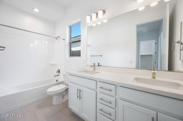 bathroom featuring double vanity, toilet, a sink, and shower / bathtub combination