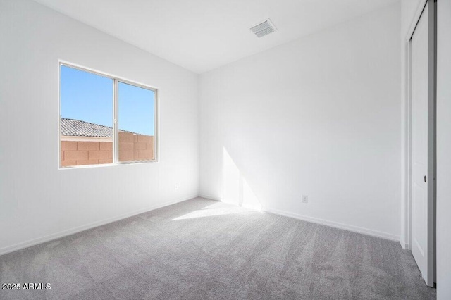 unfurnished bedroom with carpet floors, baseboards, visible vents, and a closet