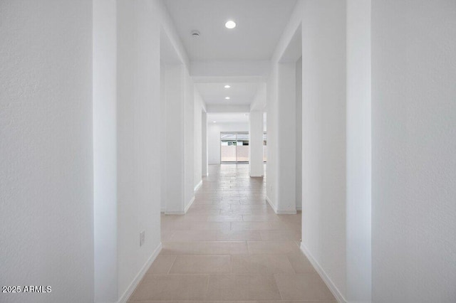 hall featuring baseboards and recessed lighting