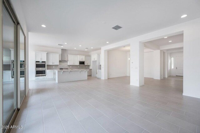 unfurnished living room featuring visible vents and recessed lighting