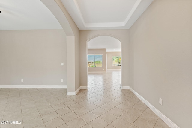 tiled empty room with a tray ceiling