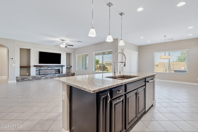 kitchen featuring sink, a fireplace, a healthy amount of sunlight, and light tile patterned floors