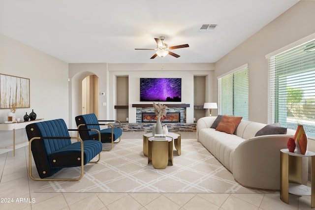 living room with ceiling fan, a fireplace, and light tile patterned floors