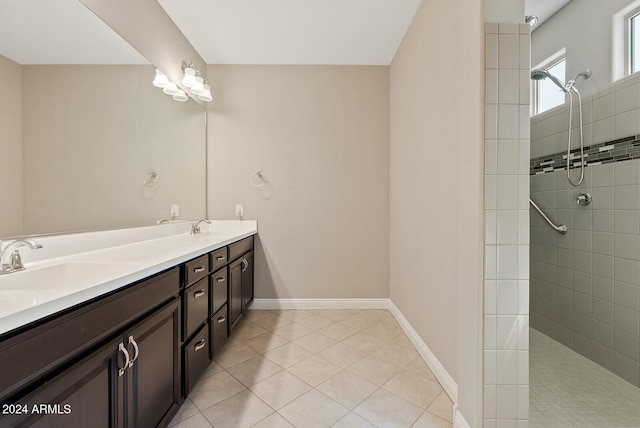 bathroom featuring tiled shower, tile patterned flooring, and vanity