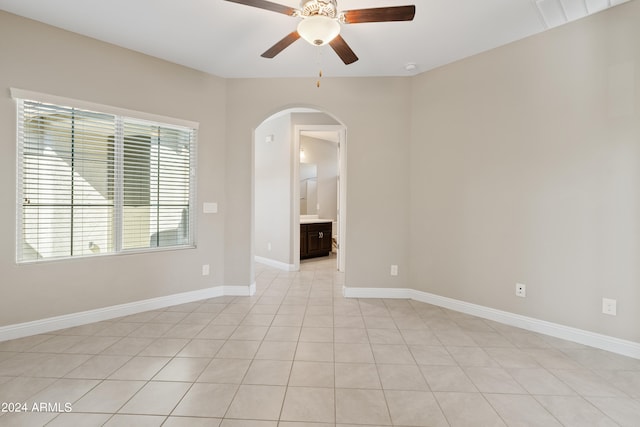 empty room with ceiling fan and light tile patterned floors