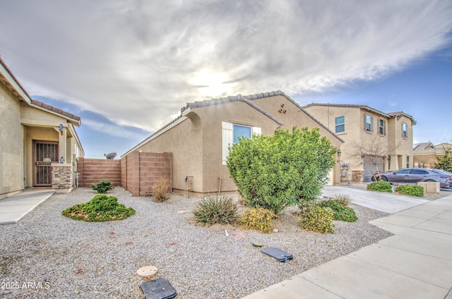 view of front of house with a garage, fence, driveway, a gate, and stucco siding