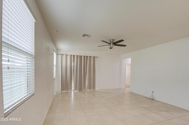 unfurnished room with light tile patterned floors, visible vents, and a ceiling fan