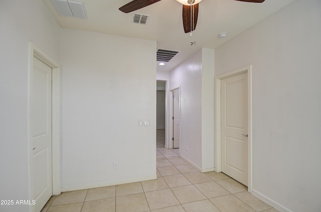 unfurnished room with light tile patterned floors, ceiling fan, visible vents, and baseboards