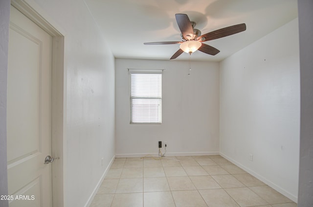 spare room featuring light tile patterned floors, baseboards, and a ceiling fan